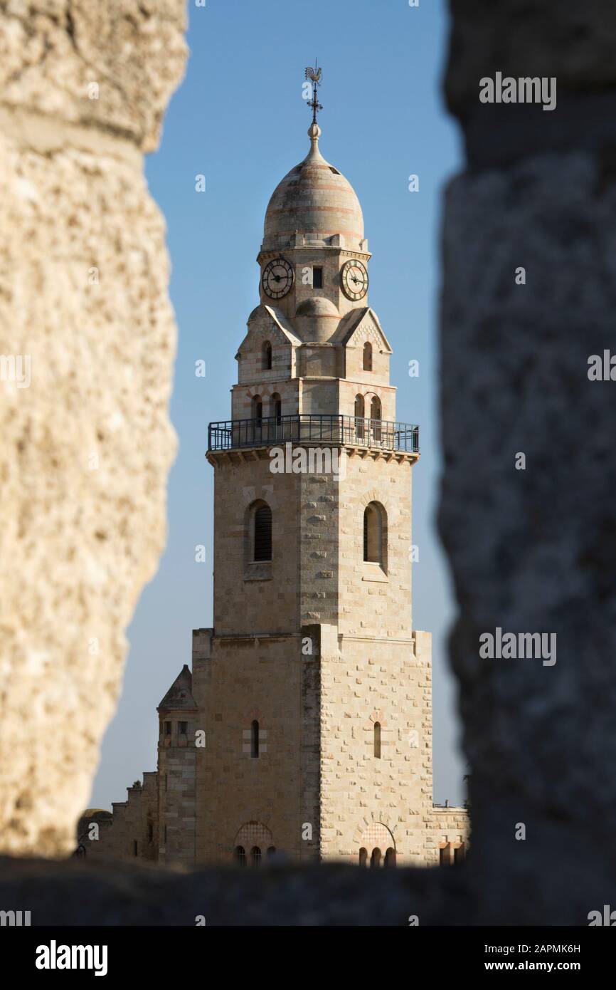Bell Tower Of Dormition Church seen through a gap in the rampart surrounding old city Jerusalem Stock Photo