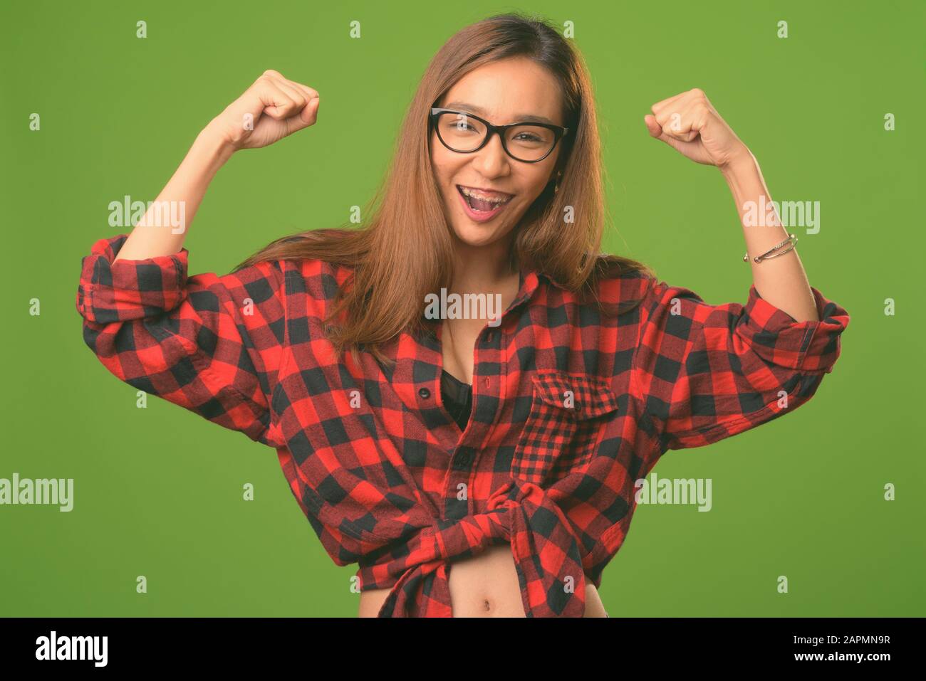 Young slim Asian hipster woman against green background Stock Photo