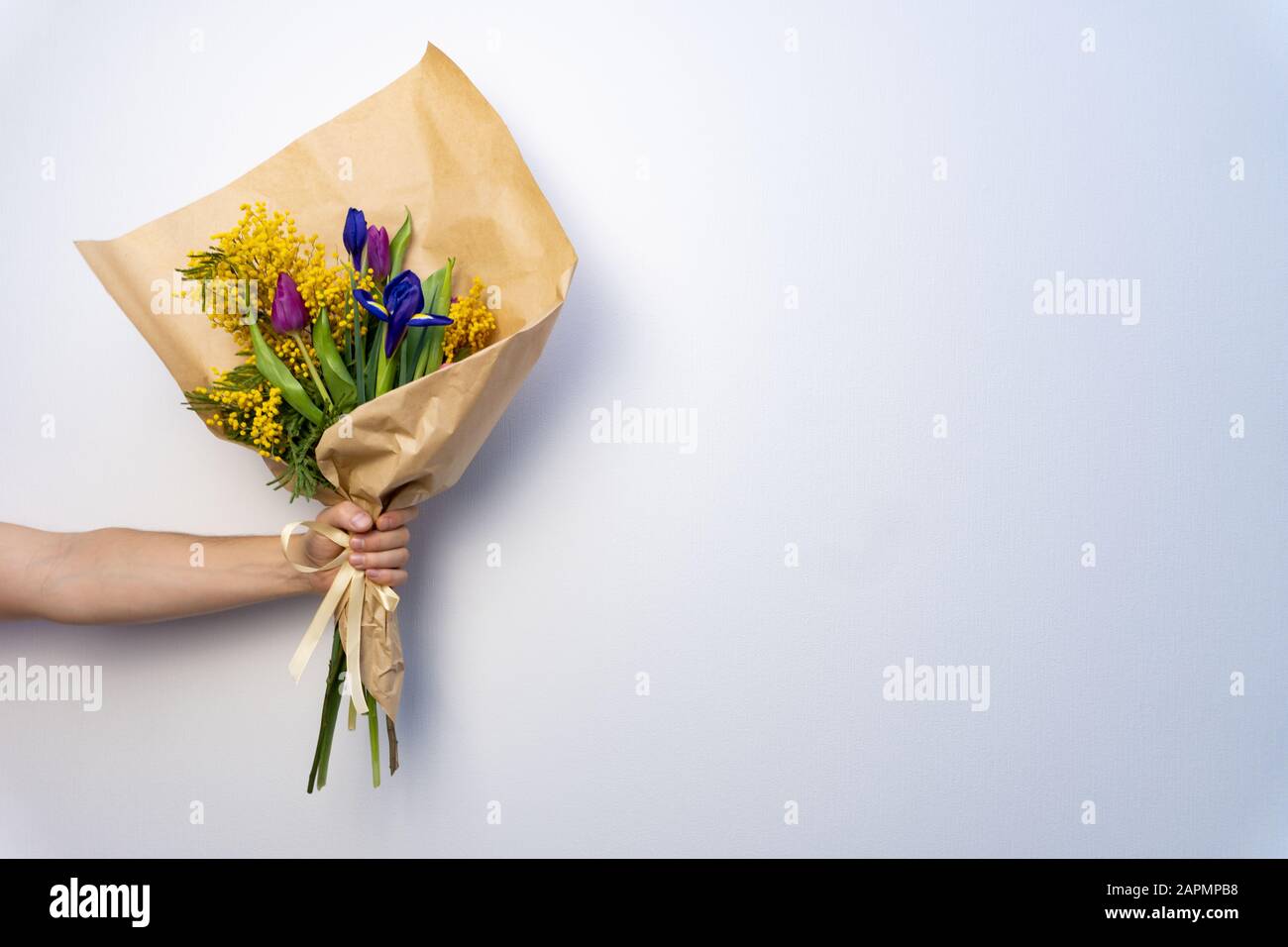 Bouquet of beautiful flowers in mans hand on white background Stock