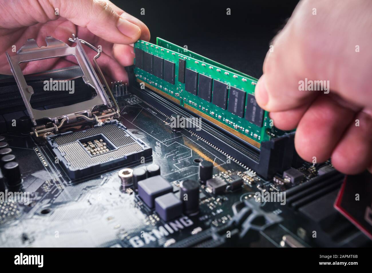 Electronic engineer of computer technology. Maintenance computer hardware upgrade of motherboard putting the Ram on the motherboard computer. Concept Stock Photo