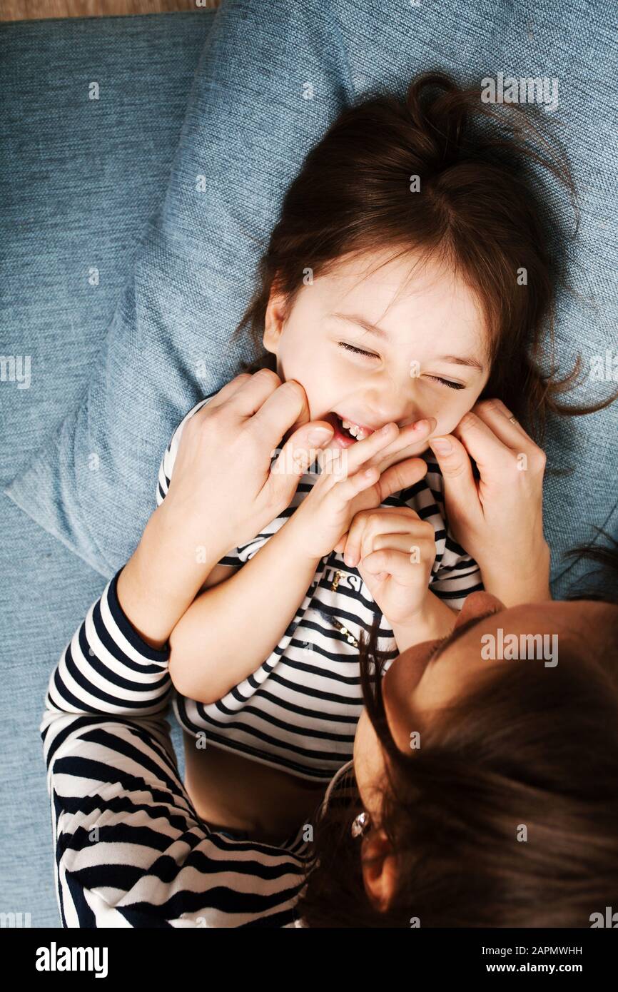 Adorable little girl 4-5 years old having fun with her mom and smiling, top view. Happy childhood. Stock Photo