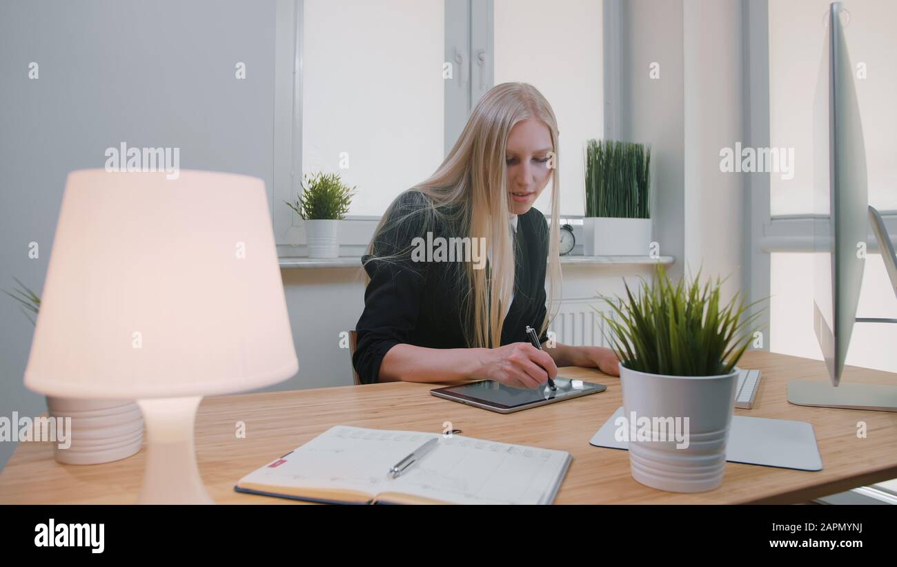 Attractive Blond Female With Long Hair In Elegant Suit Sitting At