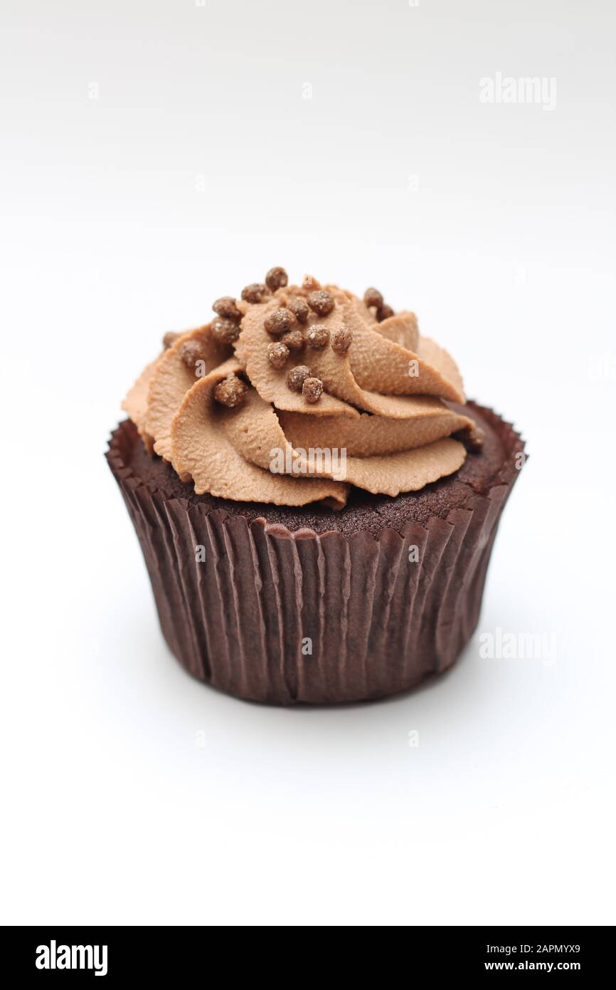 Isolated chocolate cupcake with cream top and crispy topping on a white ...