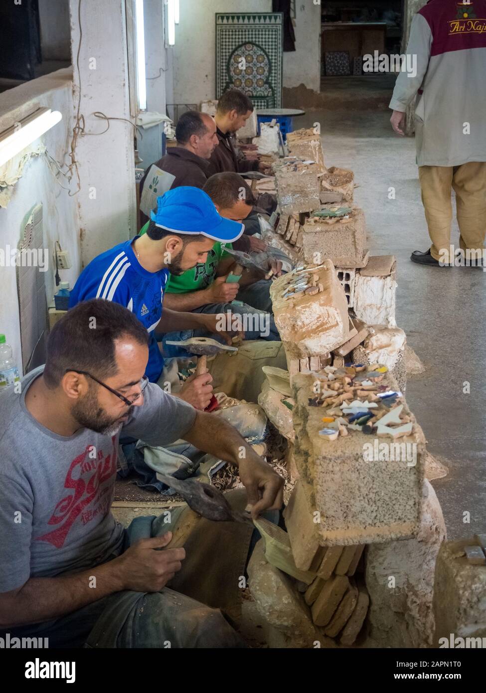 FEZ, MOROCCO Jun 05, 2018 Moroccan workers cutting ceramic pieces in