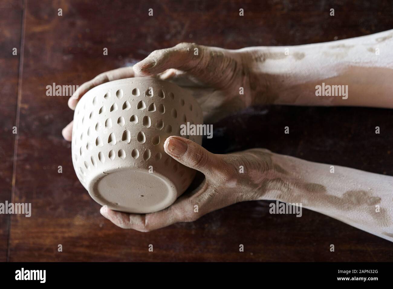 Female hands hold a wet clay bowl. Pottery making Stock Photo Alamy