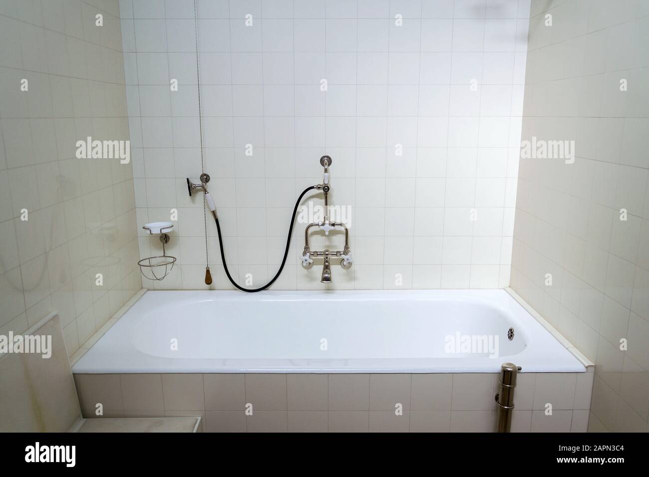Beautiful shower bath with hot and cold water taps, white tile design wall, modern functionalism architecture Stock Photo
