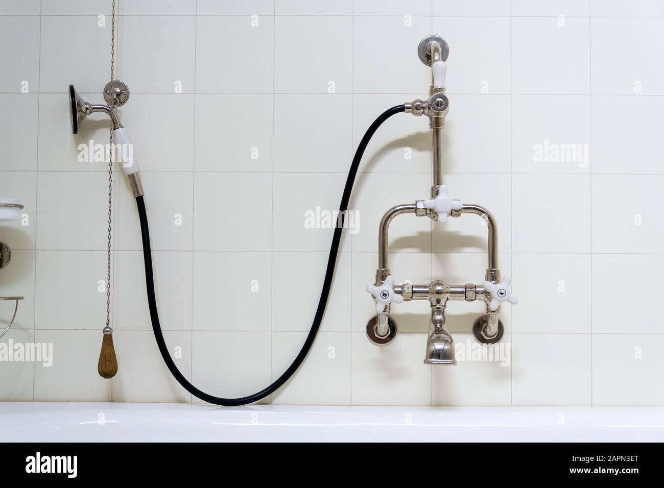 Beautiful shower bath with hot and cold water taps, white tile design wall, modern functionalism architecture Stock Photo