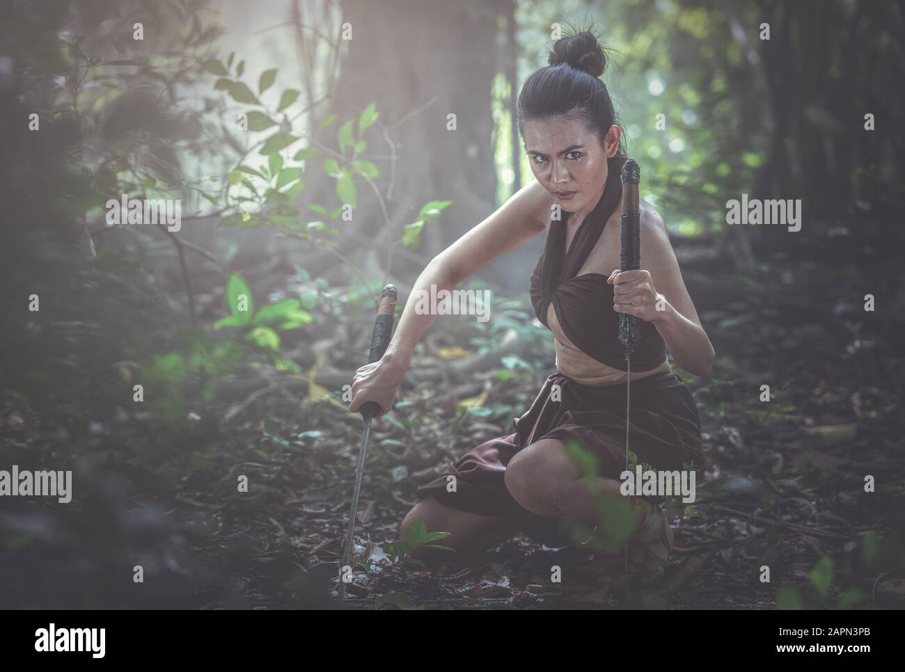Thai woman in military dress ancient of Thailand and hand holding swords ready to fight. Stock Photo
