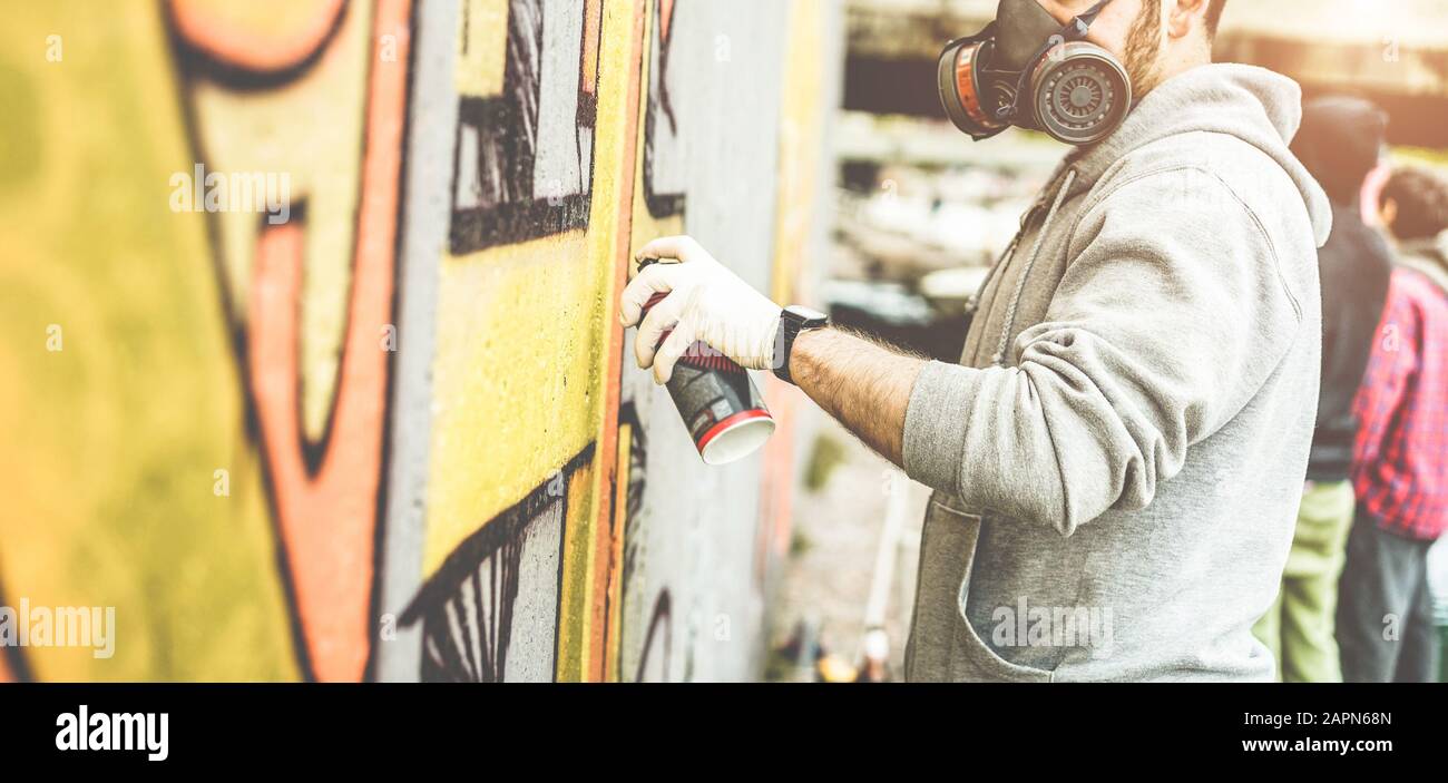 Graffiti artist painting with color spray on the wall for international ...