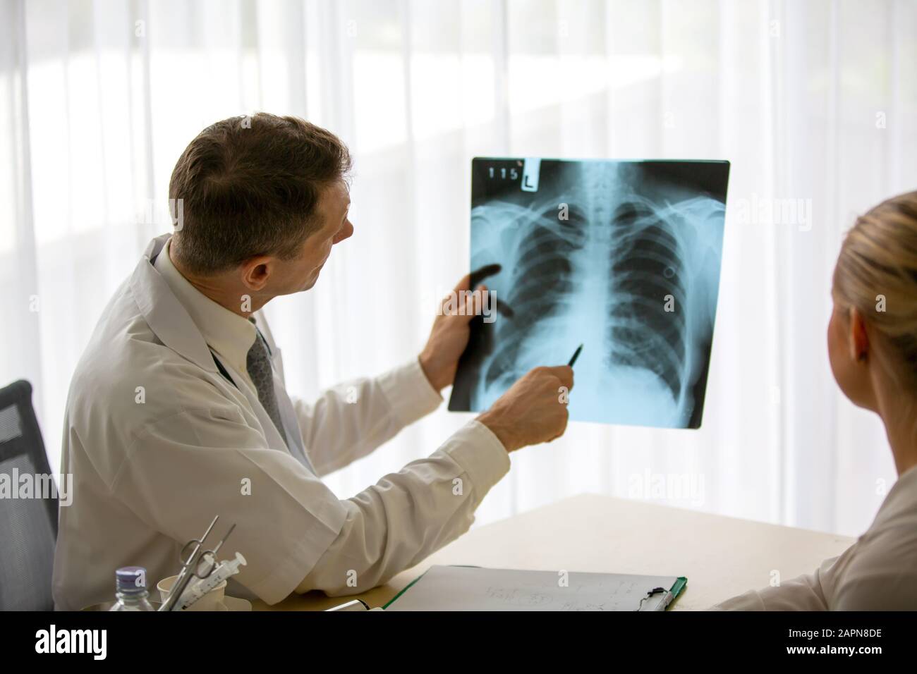 Doctor explaining lungs xray to women patient in clinic or Doctor in