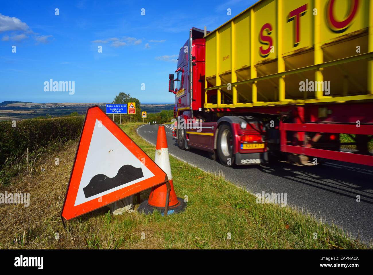 lorry passing warning sign of bumpy road/ potholes ahead staxton hill yorkshire united kingdom Stock Photo
