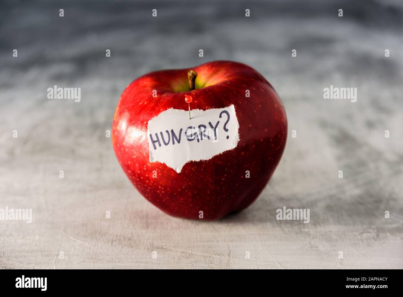 Big red apple on grey background. Dieting and weight loss concept Stock Photo