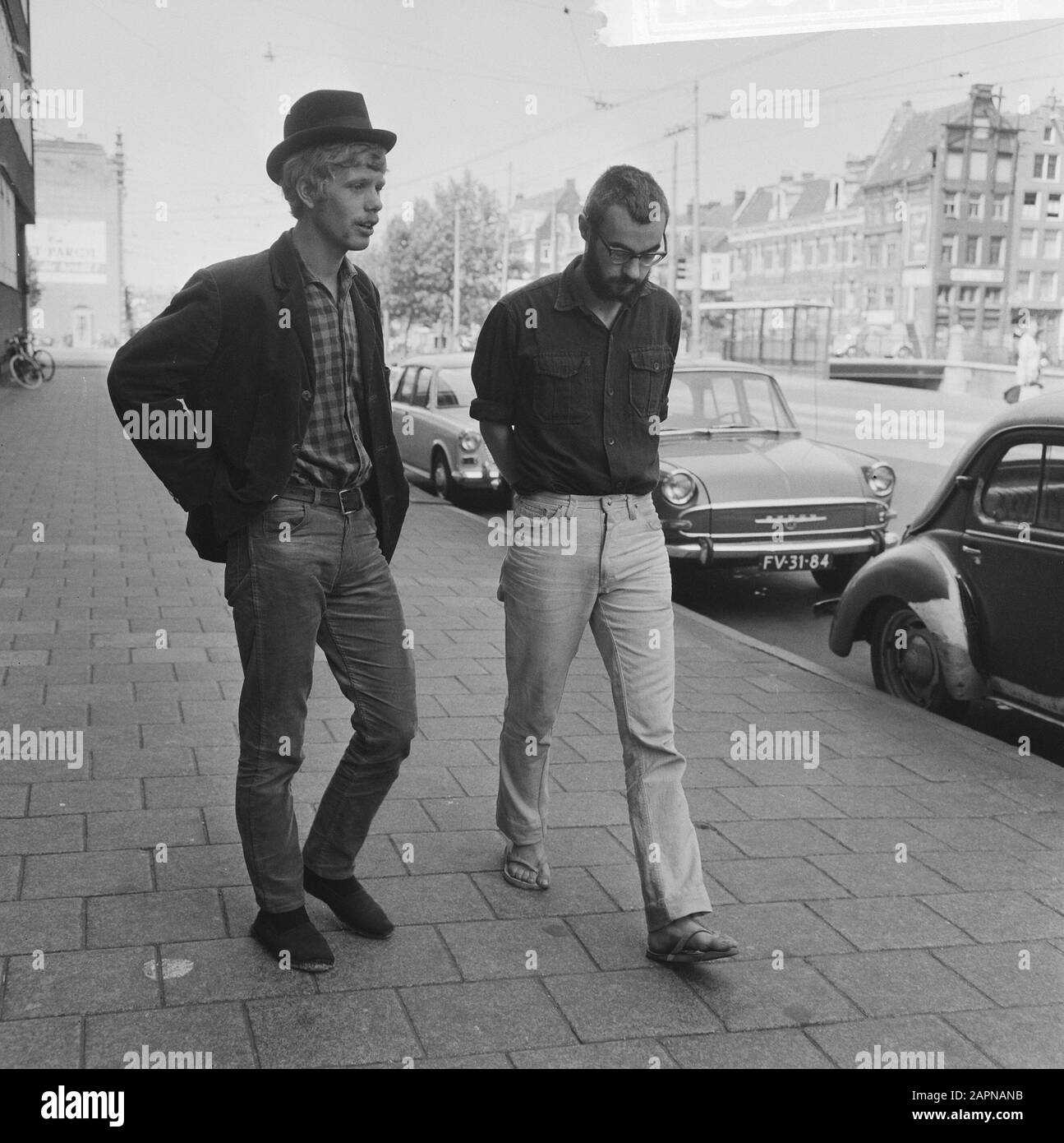 Provo's at the chief commissioner  Rob Stolk (left, with bowler hat) and Roel van Duyn Date: 14 August 1965 Location: Amsterdam, Noord-Holland Keywords: campaigners, police Personname: Duyn, Roel of, Stolk, Rob Institution name: Provo Stock Photo