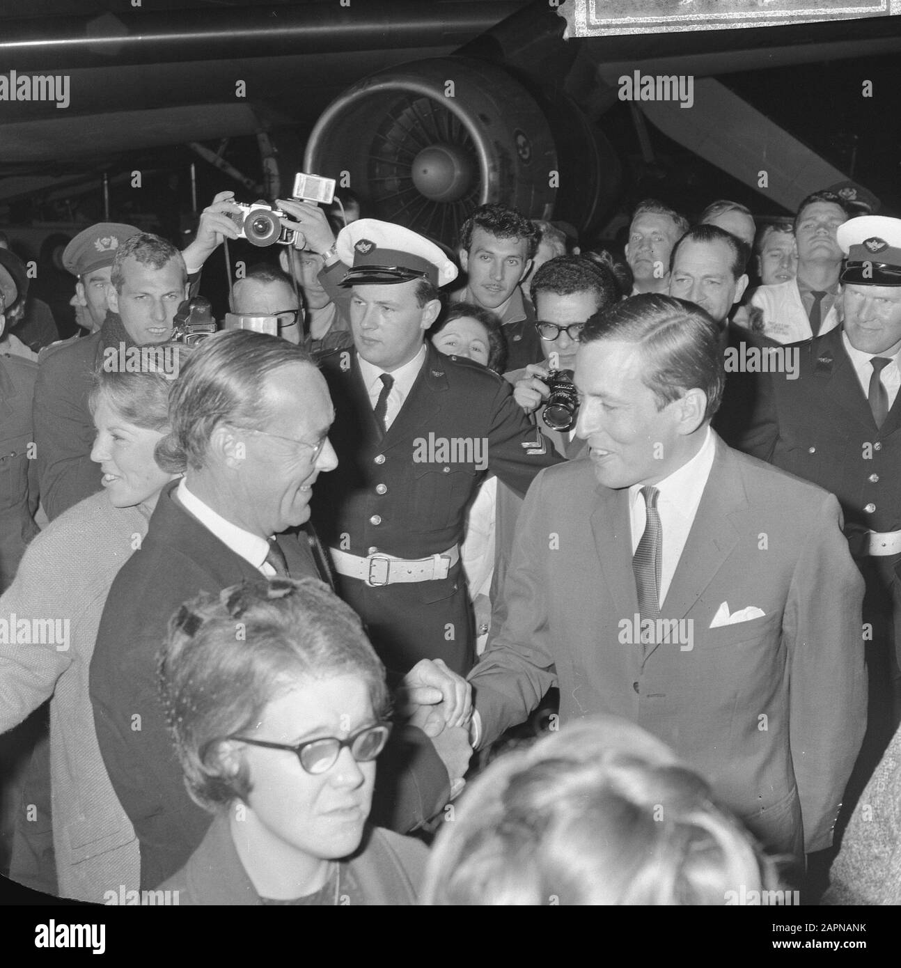 Queen Juliana and Prince Bernhard on their arrival at Schiphol Airport after a royal visit to Suriname  Prince Bernhard while greeting his future son-in-law Claus von Amsberg Date: 16 October 1965 Location: Noord-Holland, Schiphol Keywords: arrival and departure, greetings, press photographers, princes Personal name: Bernhard, prince, Claus, prince Stock Photo