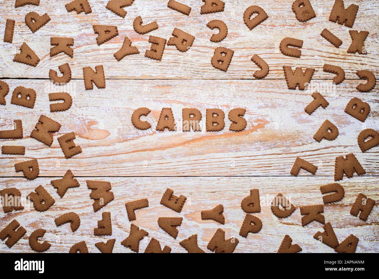 Word CARBS made from cookies on white wooden background Stock Photo