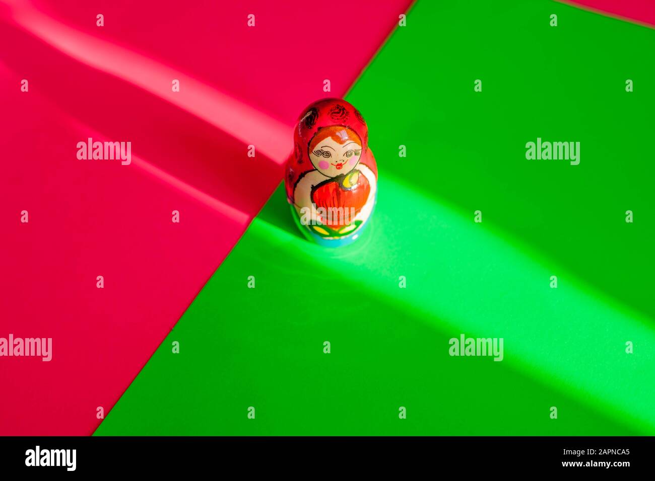Still life - colourful painted Matryoshka (Russian) doll on a neon pink & green background. Stock Photo