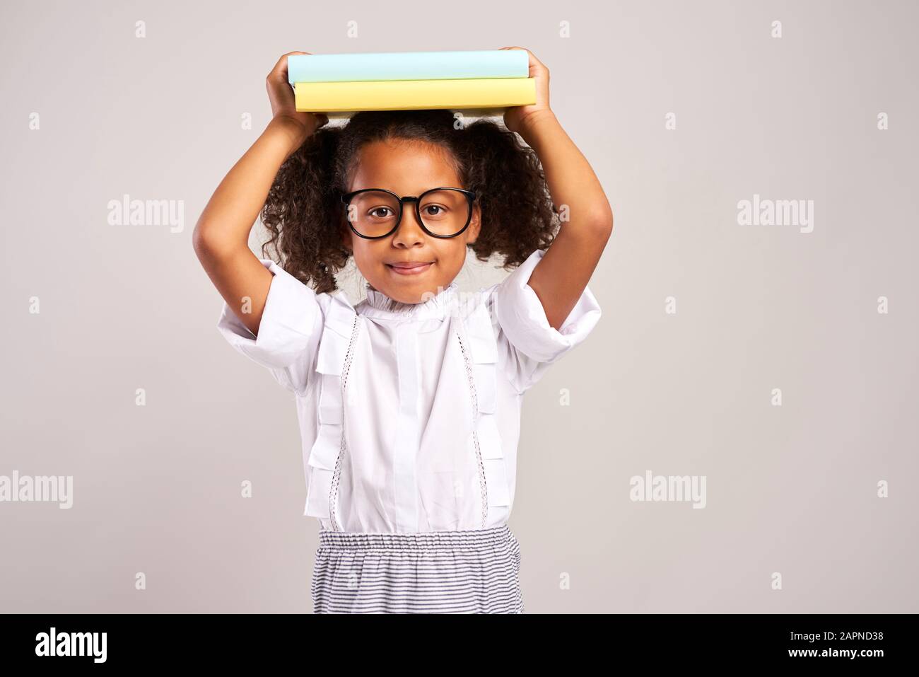 Happy student with books on her head Stock Photo - Alamy