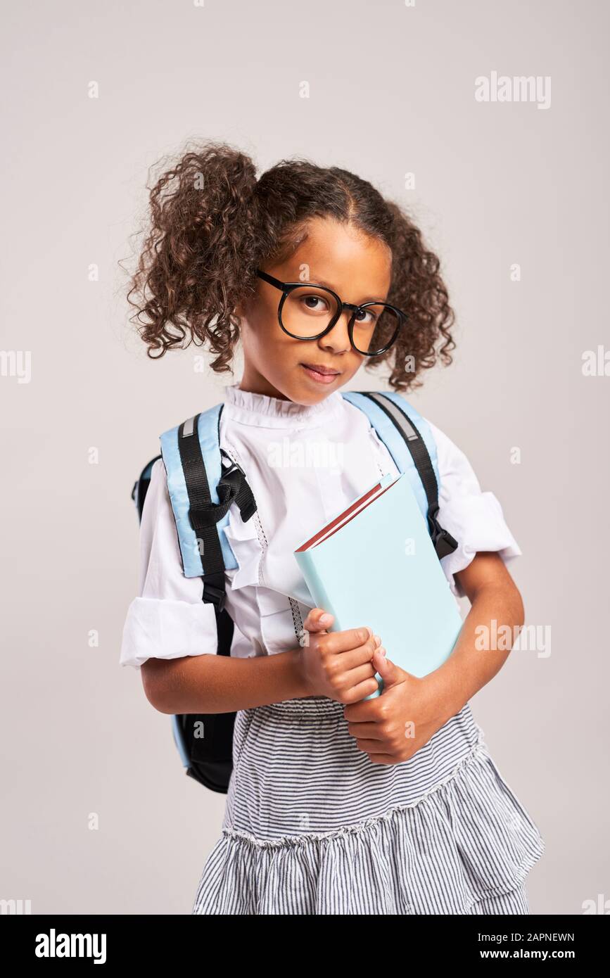 Happy student with backpack holding a book Stock Photo - Alamy