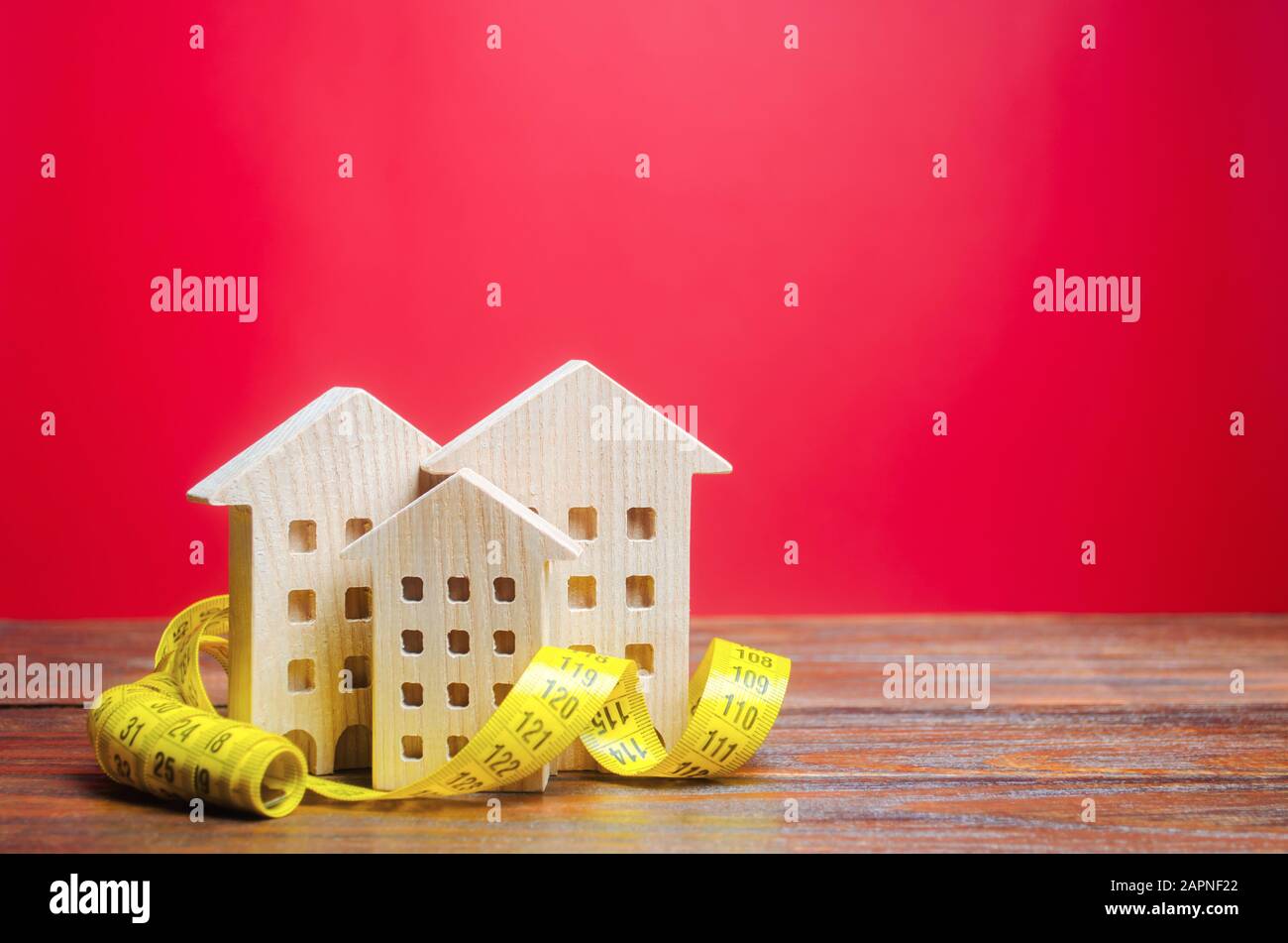 Miniature wooden houses and measuring tape. Home appraisal and property valuation concept. Housing construction, repair and maintenance. Real estate a Stock Photo
