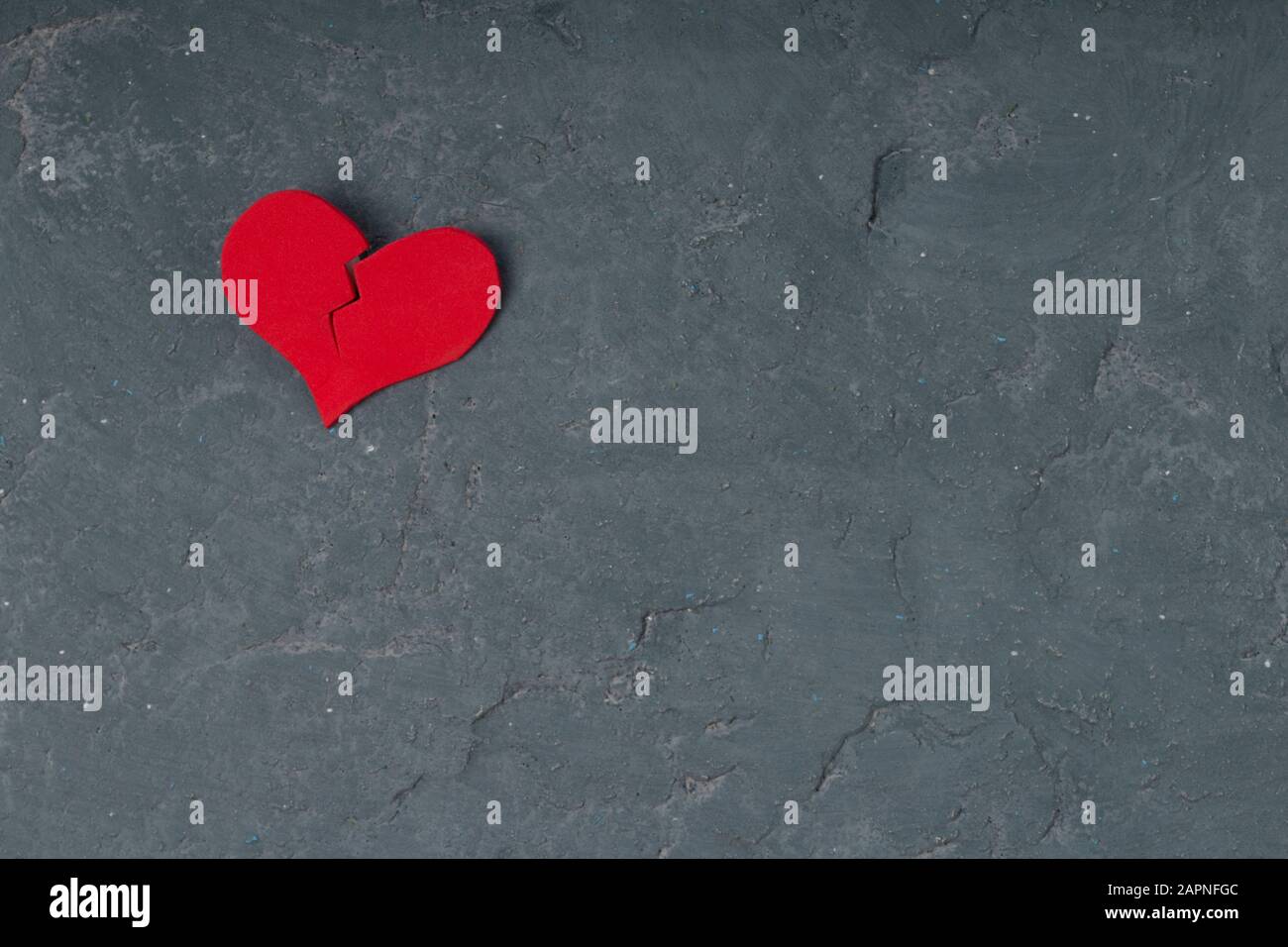 Heart broken  on grunge cement wall background - love concept. copy space Stock Photo