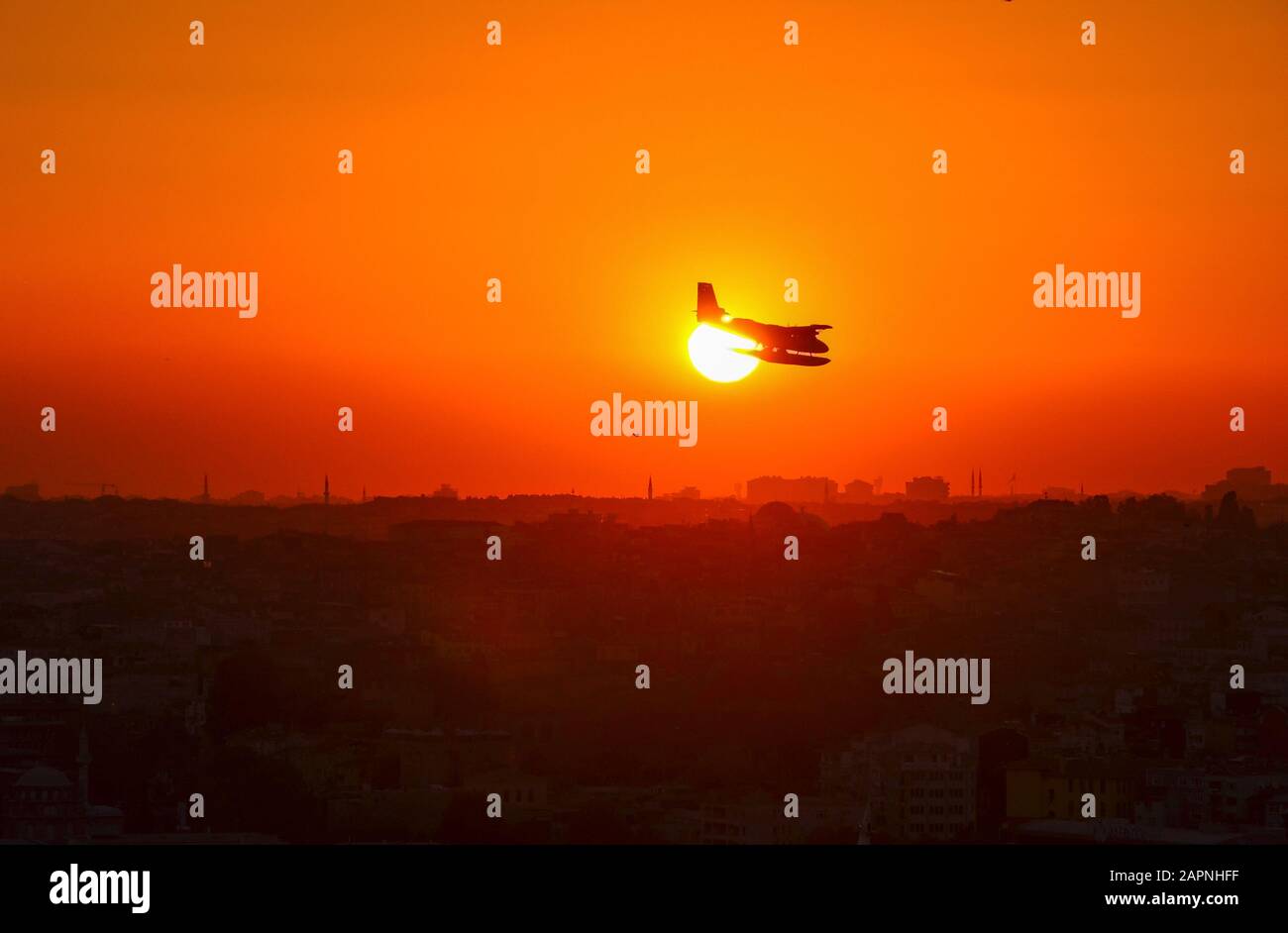 Plane flying above Istanbul at sunset Stock Photo