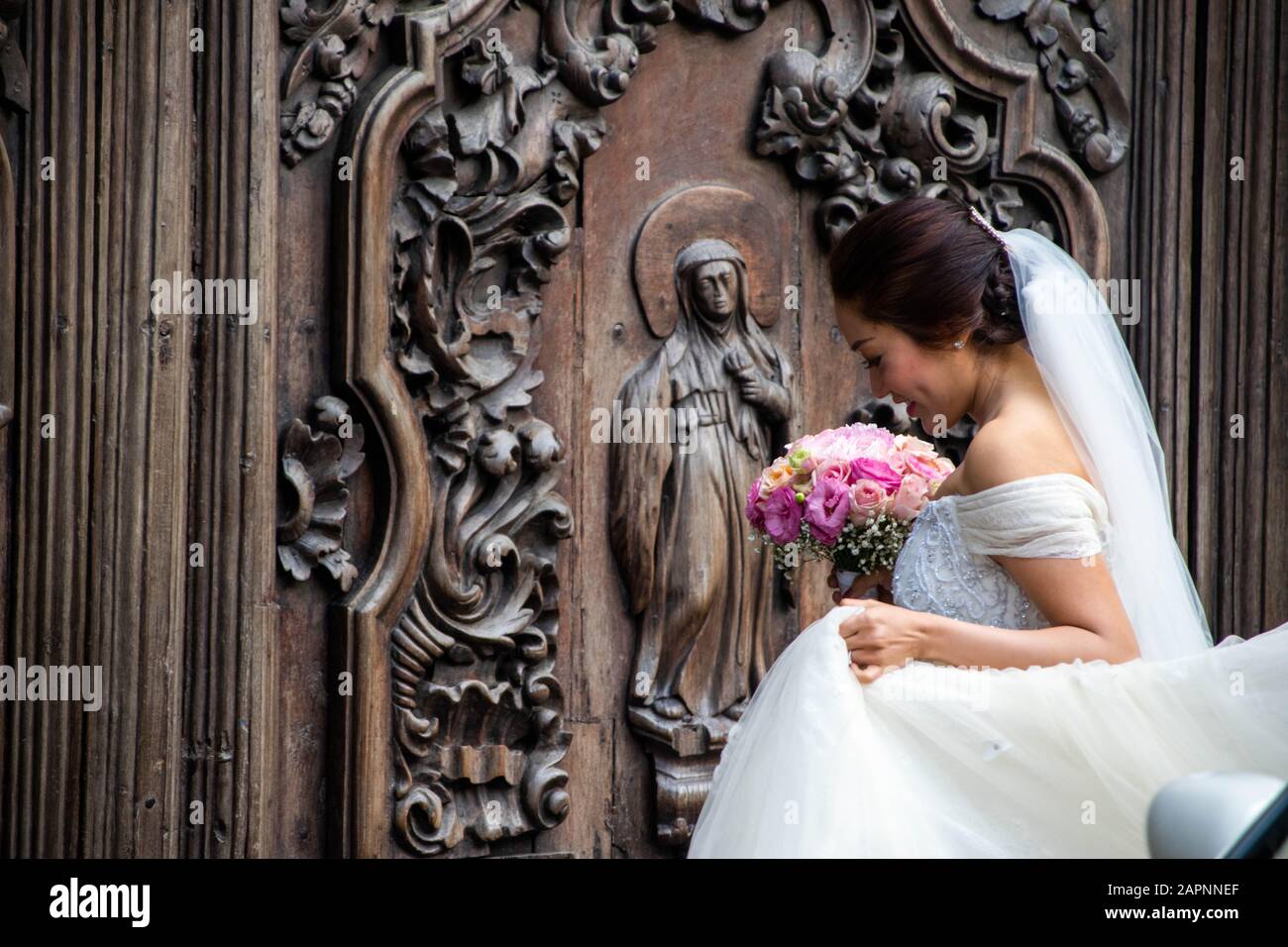 Bride in her wedding dress and veil outside the San Agustin Church in