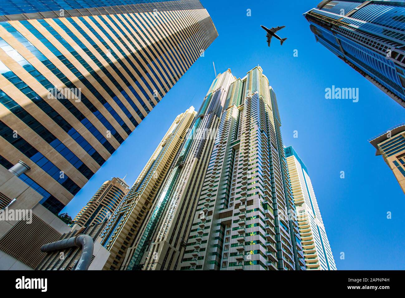 Aeroplane flying past skyscrapers, Dubai Stock Photo