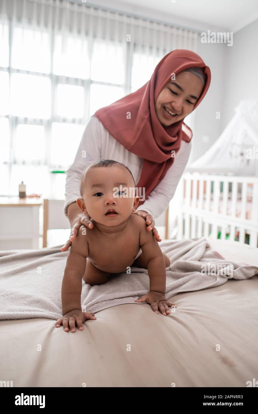 muslim mother giving a baby boy massage during diaper change Stock Photo -  Alamy