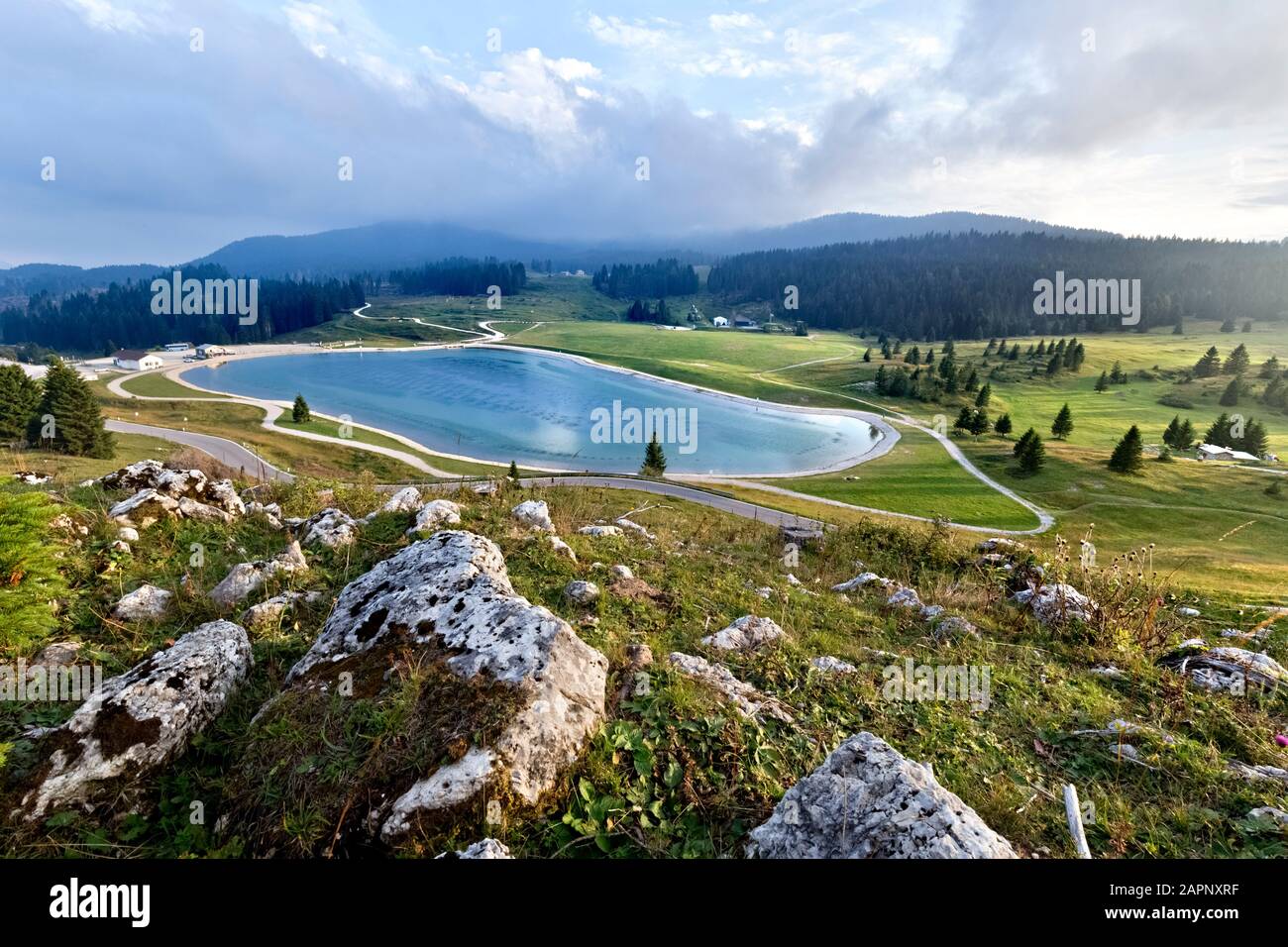 The lake and meadows at the Coe pass: Base Tuono museum on the right, Mount Maggio in the background. Folgaria, Cimbra Alp, Trentino, Italy. Stock Photo