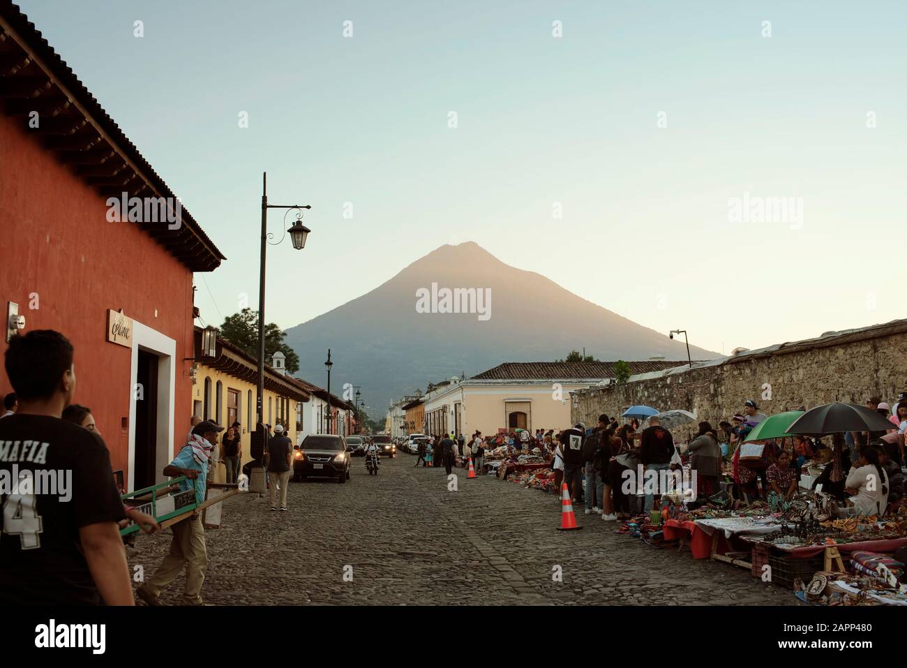 Busy street view of local artisan market and Volcan de Agua in the background. Iglesia del Carmen, Antigua, Guatemala. Jan 2019 Stock Photo