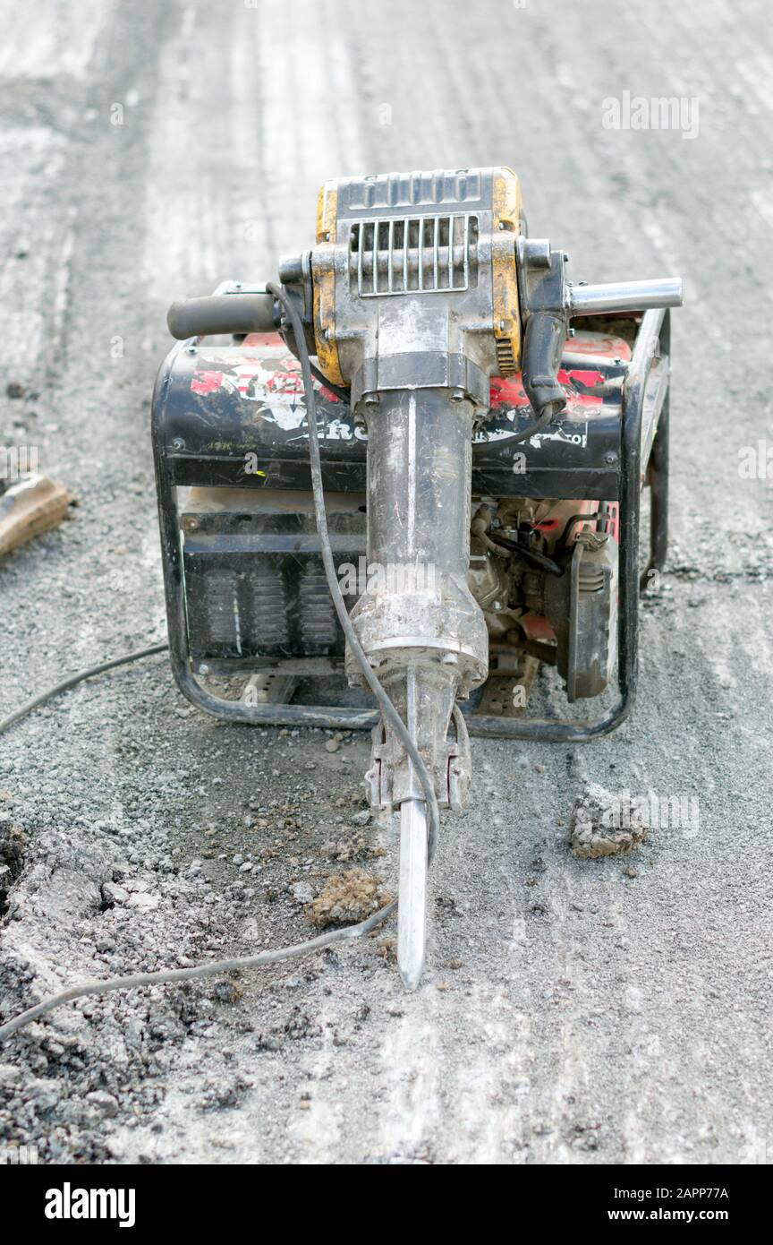 Pneumo electric jackhammer, which opened the surface of the asphalt. Russia. Stock Photo