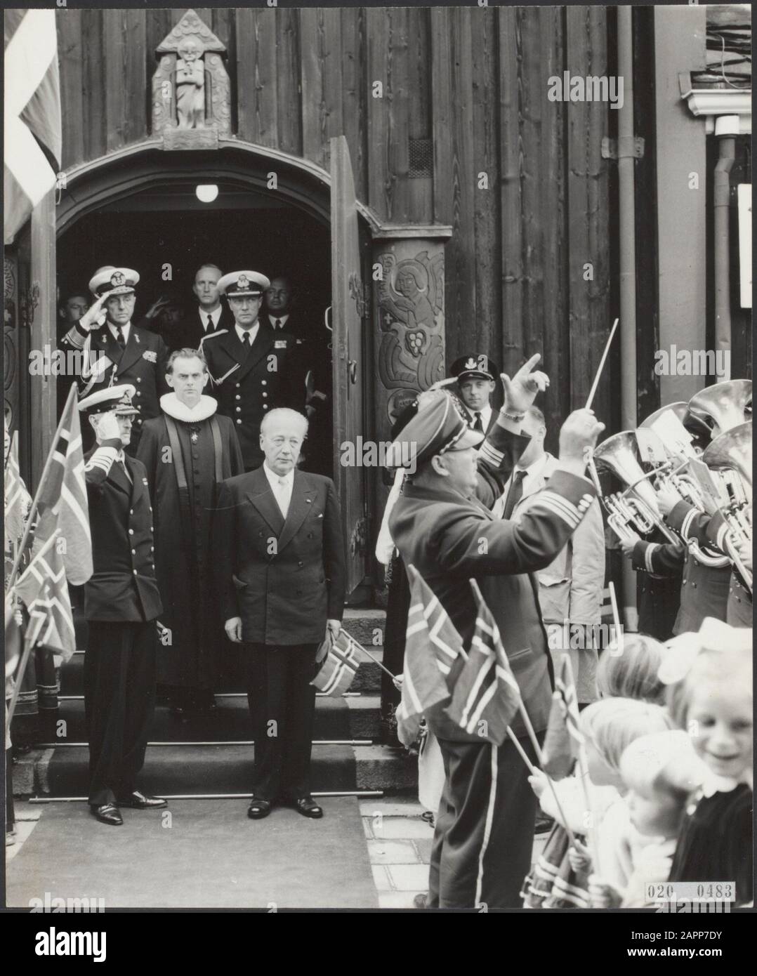 Rotterdam, Norwegian sailor church at the Westzeedijk. Visit of the King of Norway to the church. The royal company, together with the preacher, leaves the building under the sounds of a fanfare corps Date: 1954 Location: Rotterdam, Zuid-Holland Keywords: conductors, church buildings, orchestras, pastors, state visits, royal houses Personal name: Haakon VII (King Norway) Stock Photo