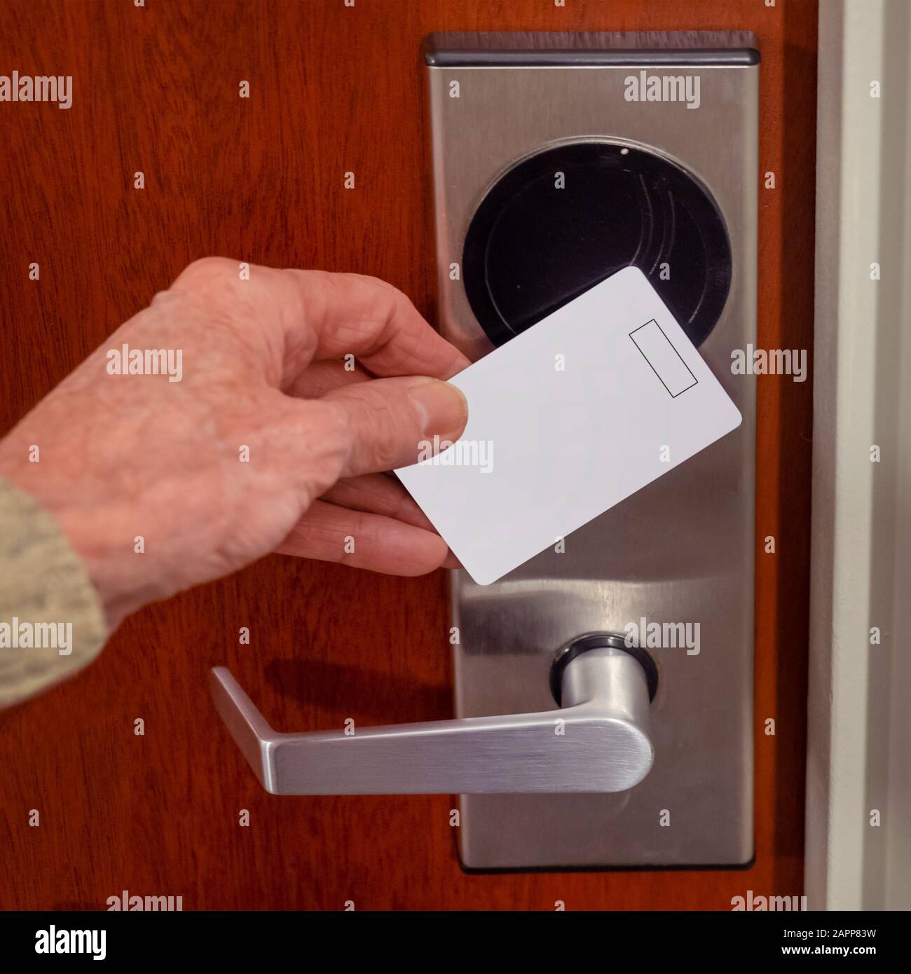 hand swiping key card to open hotel room door. Holding magnetic card for door access control swiping key card to lock and unlock door Stock Photo