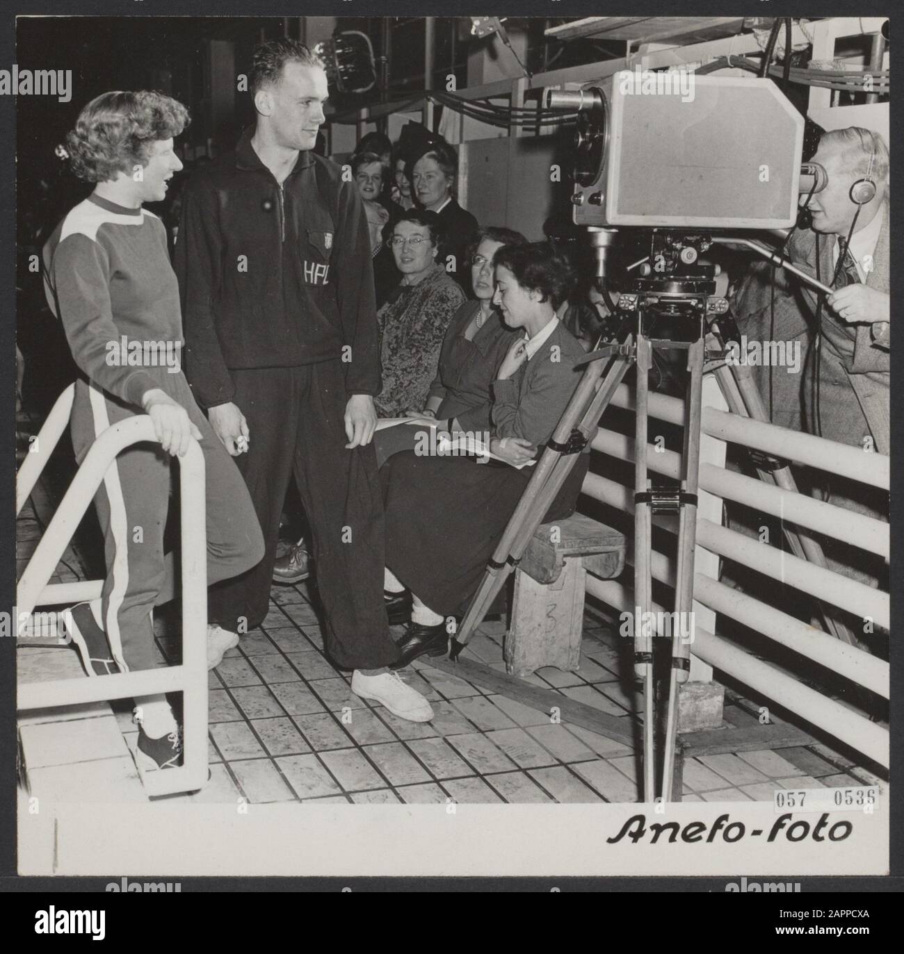 National swimming competitions in the swimming stadium in Naarden organized by the AVRO and broadcast in a direct television broadcast. Irma Schuhmacher and Joris Tjebbes for the camera to be introduced to the television audience Annotation: See 904-9191 Date: 11 January 1952 Location: Naarden Keywords: television, swimming Stock Photo