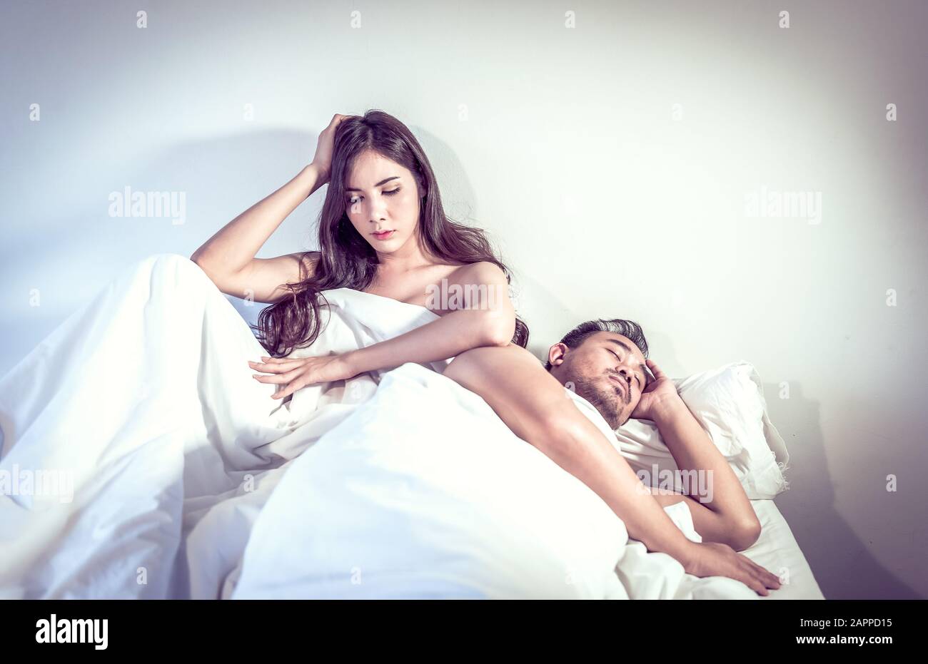 Marriage couple marital problems in bed. Sex problem or other. Woman looking  unhappy at man sleeping with back turned. Young multiracial couple Asian  Stock Photo - Alamy