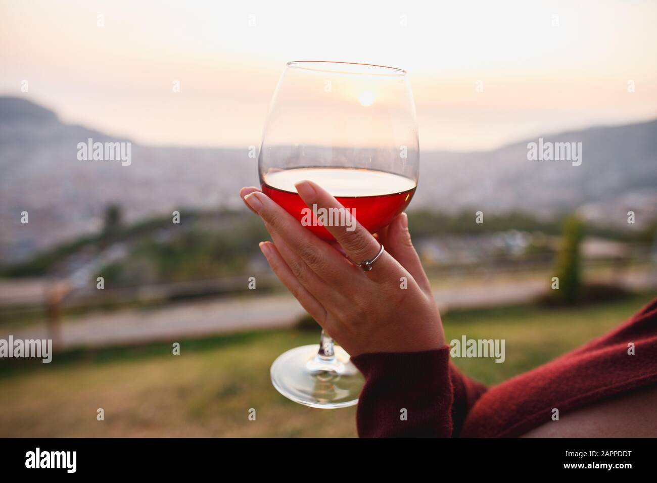 Woman with red wine on sunset mountains, close up of hand holding ...