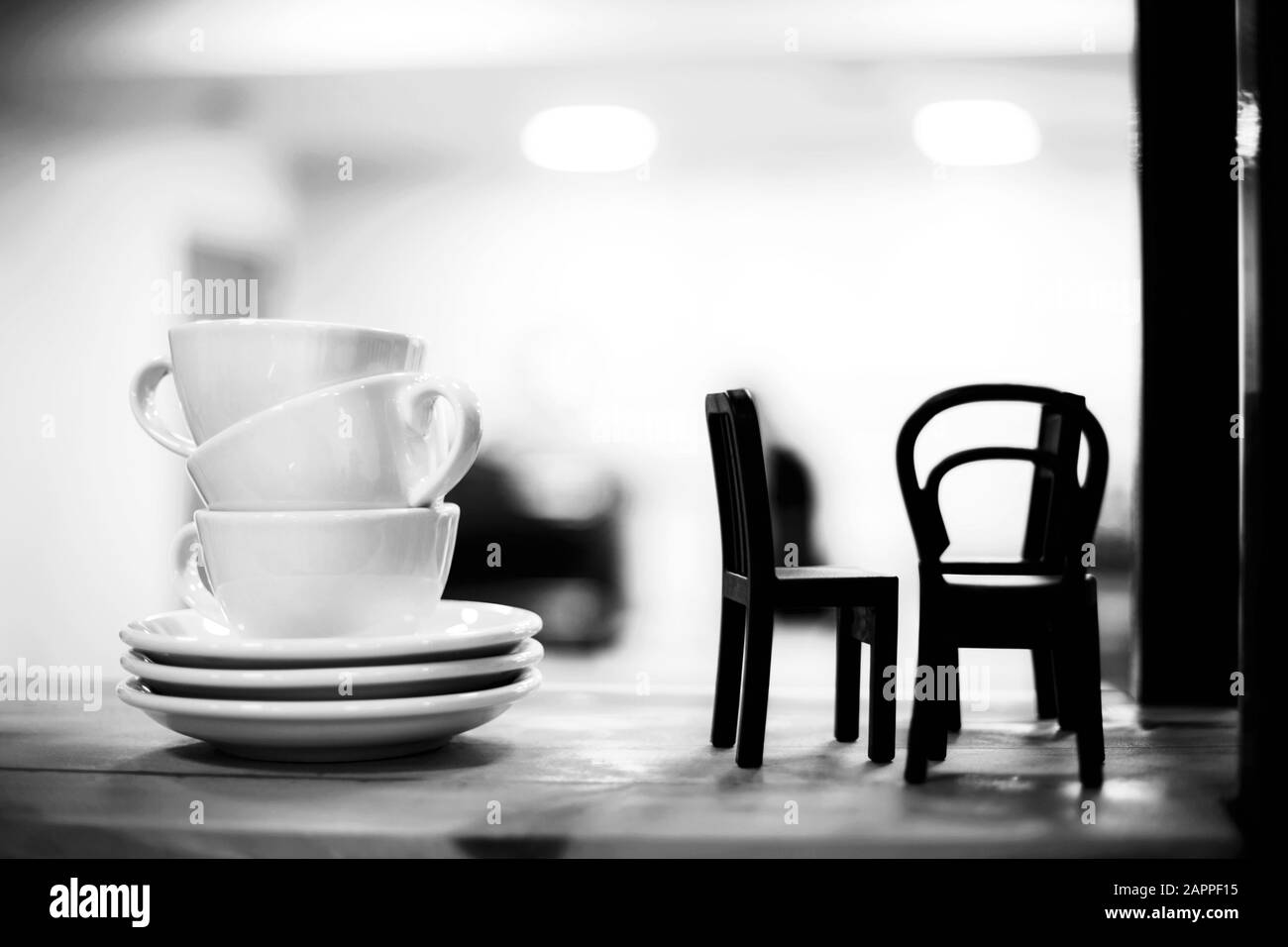Pile of coffee cups with little chairs on the shelf in cafe. Interior