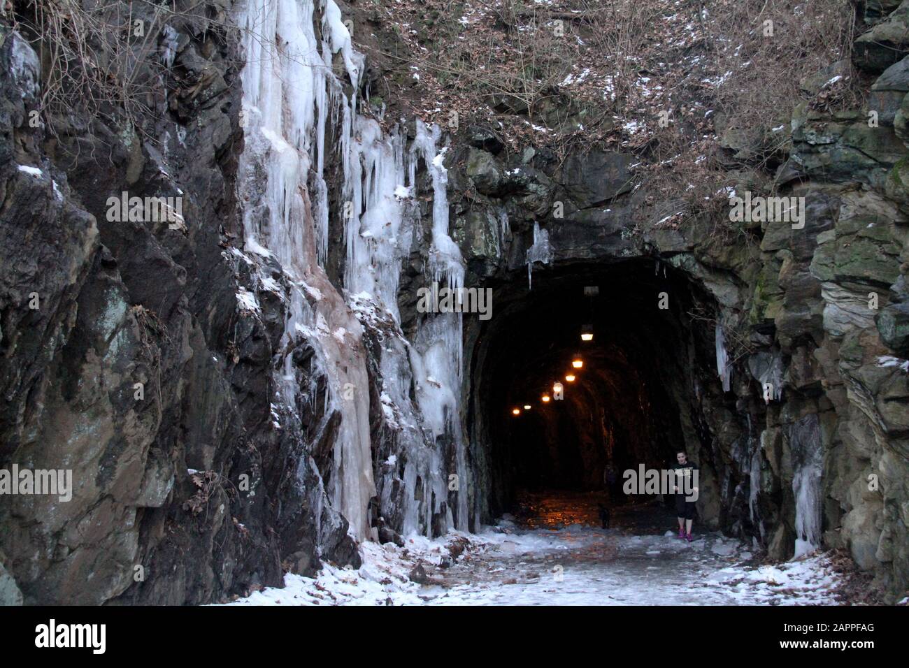Large icicles covering rocky slope Stock Photo