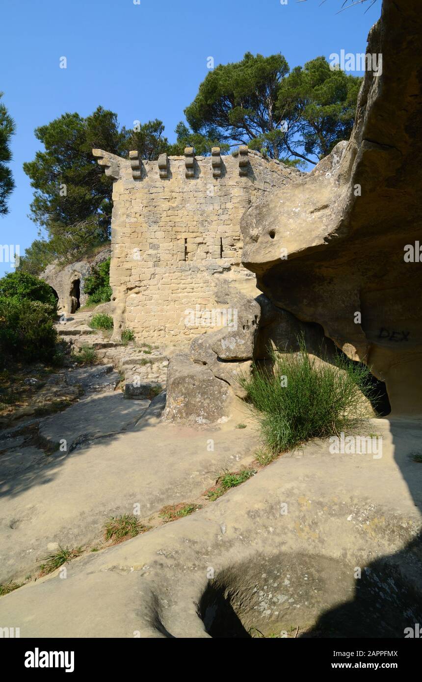 Medieval Ramparts protecting the Troglodyte Grottes de Calès, an Abandoned Prehistoric and Medieval Village at Lamanon Provence France Stock Photo