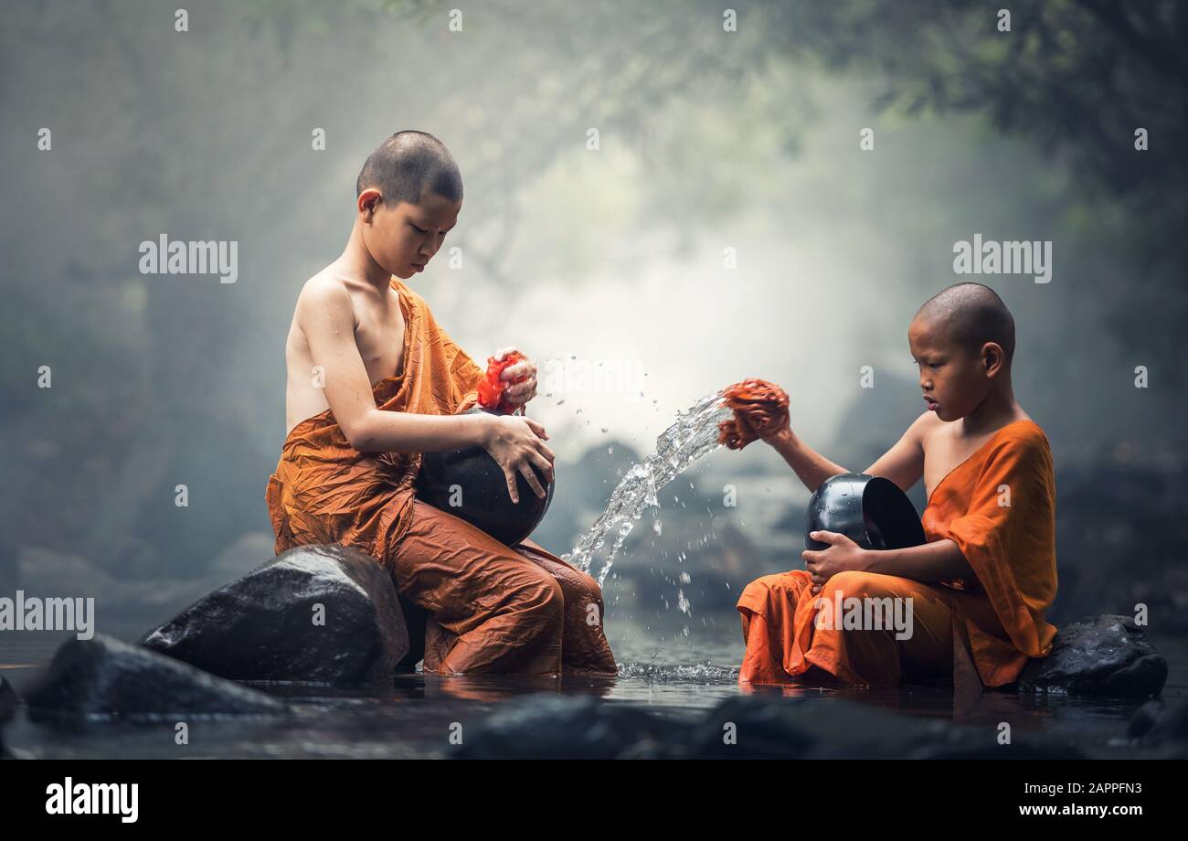 Asian Novice monks cleaning alms bowl in creeks Stock Photo