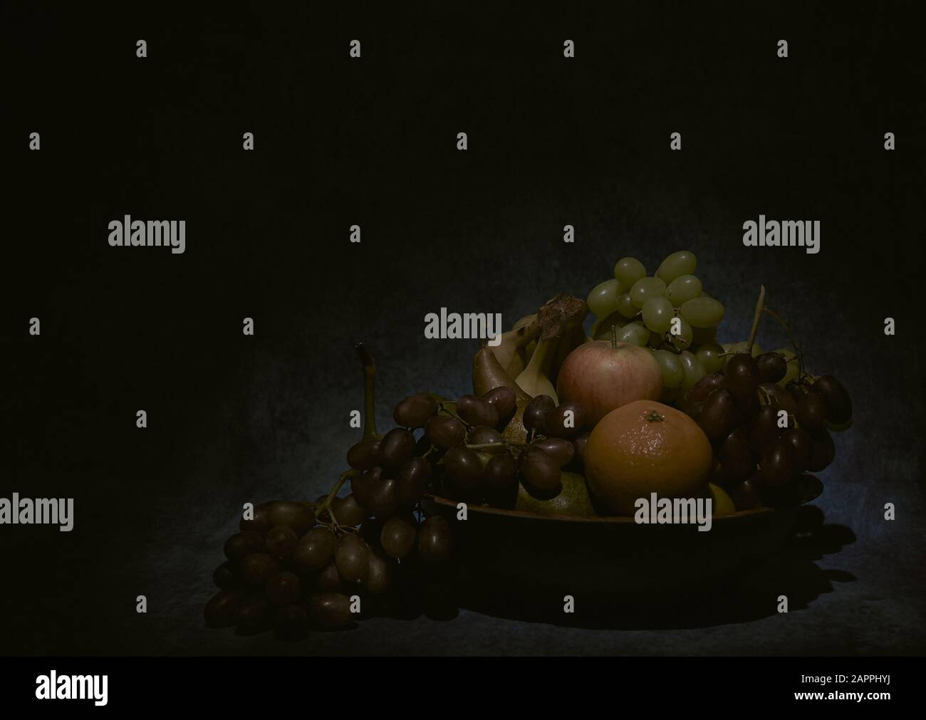 fruit bowl wit hanging grapes, in the style of the great 17th century dutch painters Stock Photo