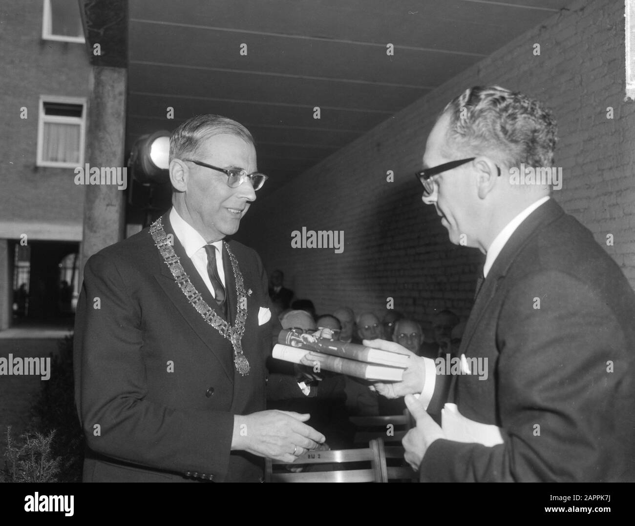 Minister Vrolijk (right) handed Mayor Van Hall the book Uné in the former theatre in Amsterdam Date: 22 april 1965 Location: Amsterdam, Noord-Holland Keywords: books , mayors, transfers, theatres Personal name: Vrolijk, Maarten Stock Photo