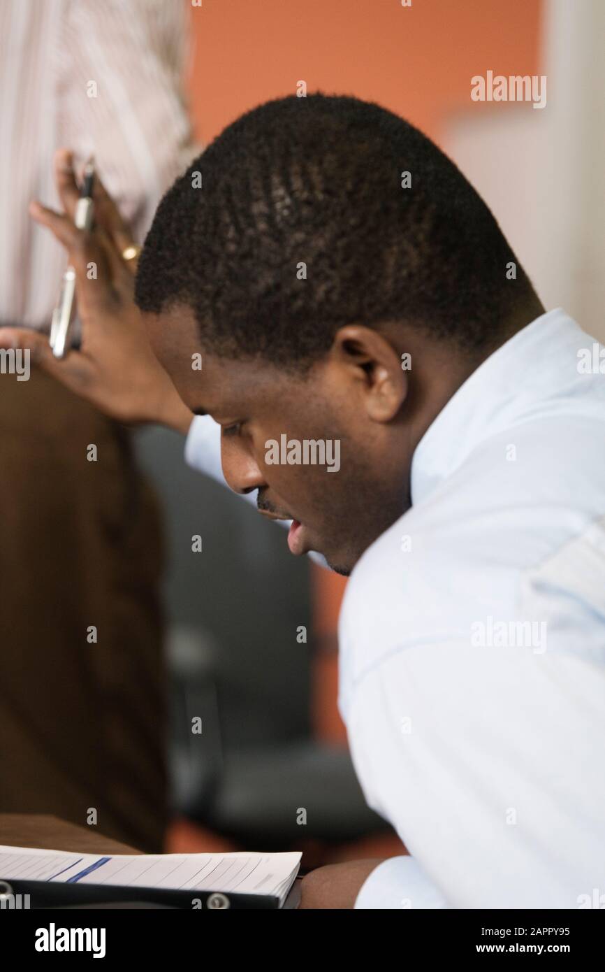 A Business man gesturing in an office. Stock Photo