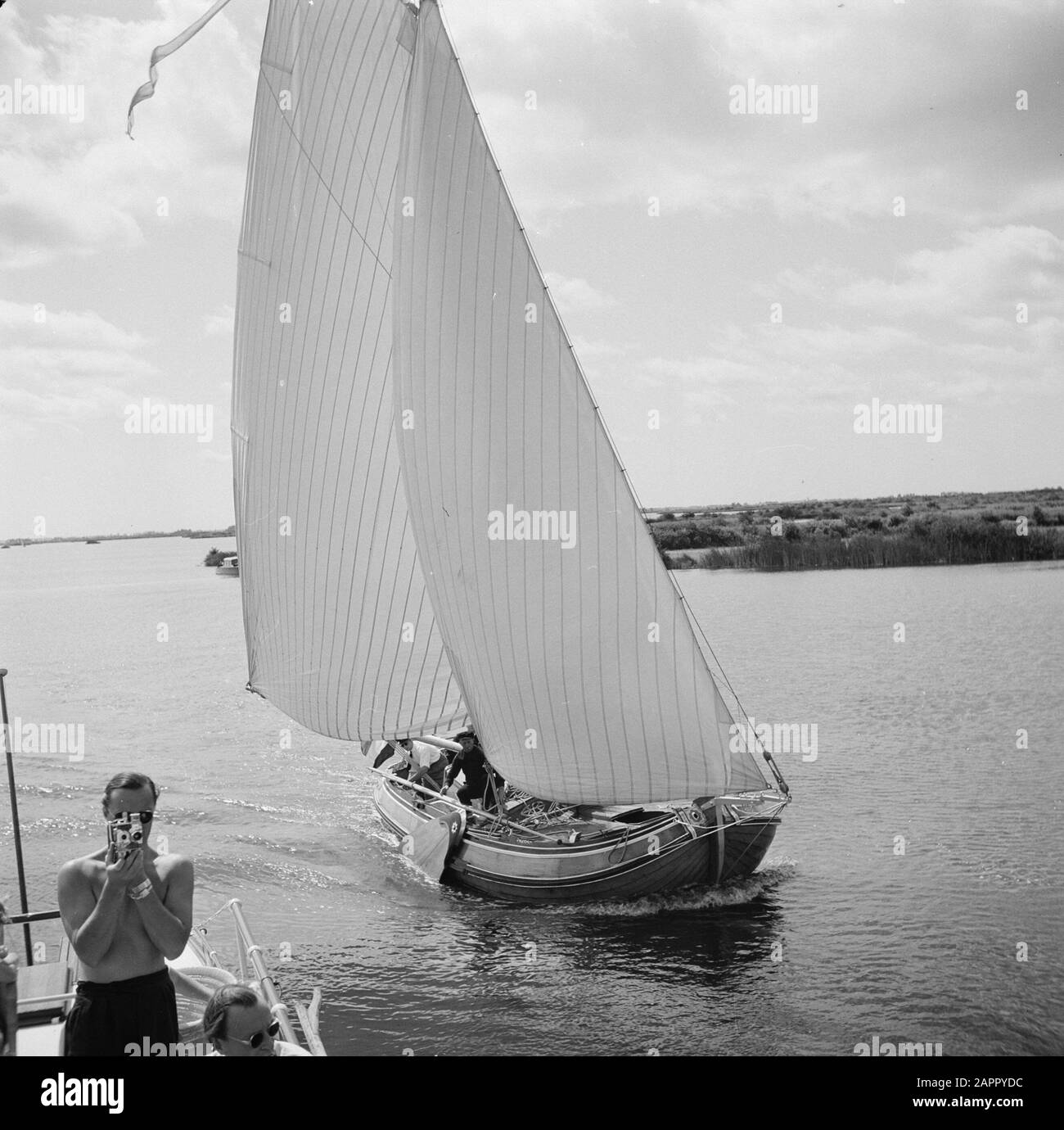 The princely family in Friesland  Prins Bernhard films from the aft deck of a boat Date: 1947 Location: Friesland Keywords: film cameras, royal house, lakes, princes, sailing ships Stock Photo