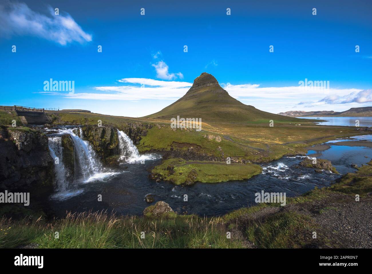 Summer sunset over the famous Kirkjufellsfoss Waterfall with Kirkjufell mountain in the background in Iceland. Long exposure. Stock Photo