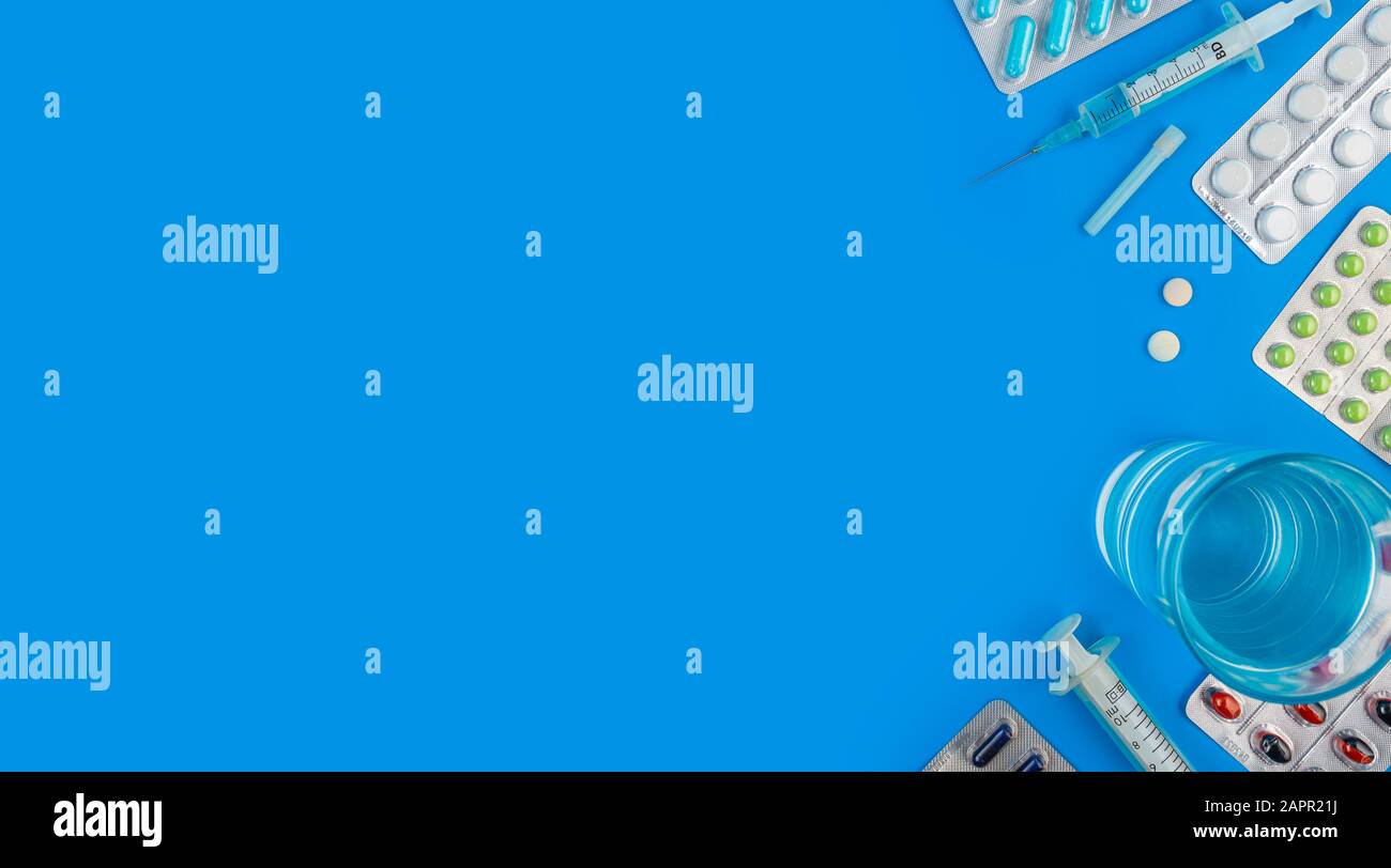 Colored pills and tablets on a blue background with copy space Stock Photo