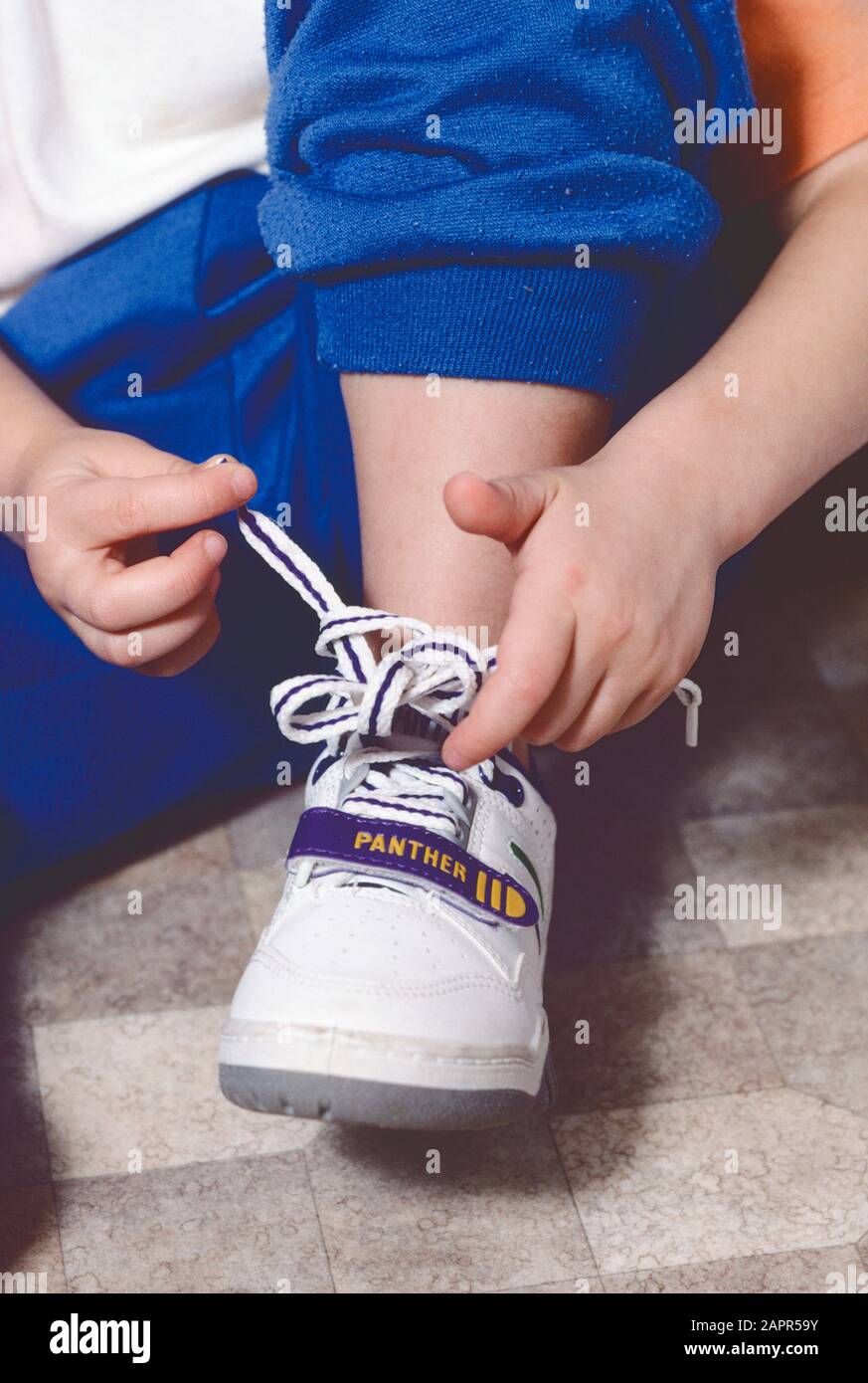 child learning how to tie the knot in shoe laces Stock Photo