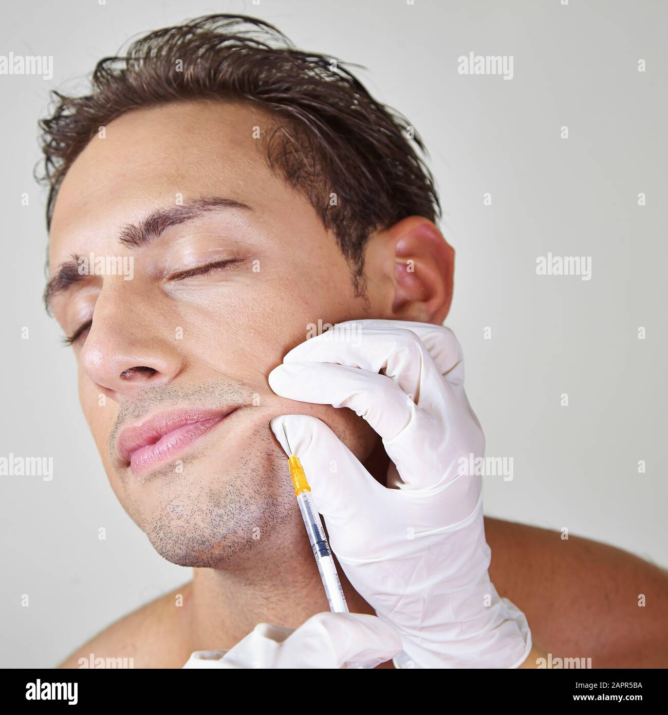 Man lets wrinkles at the corner of his mouth splash off with Botox Stock Photo
