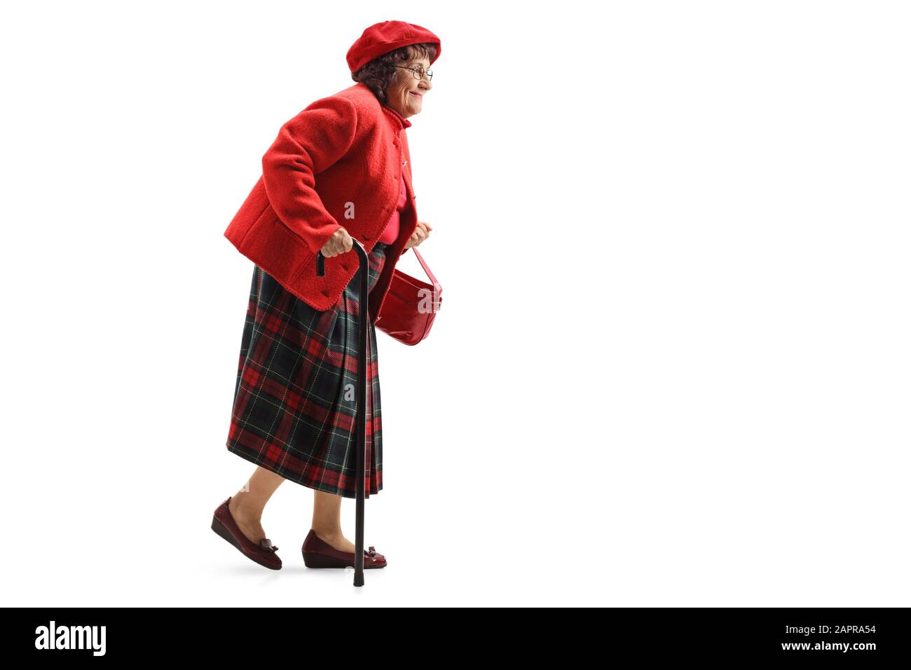 Full length profile shot of a smiling senior woman walking with a cane isolated on white background Stock Photo