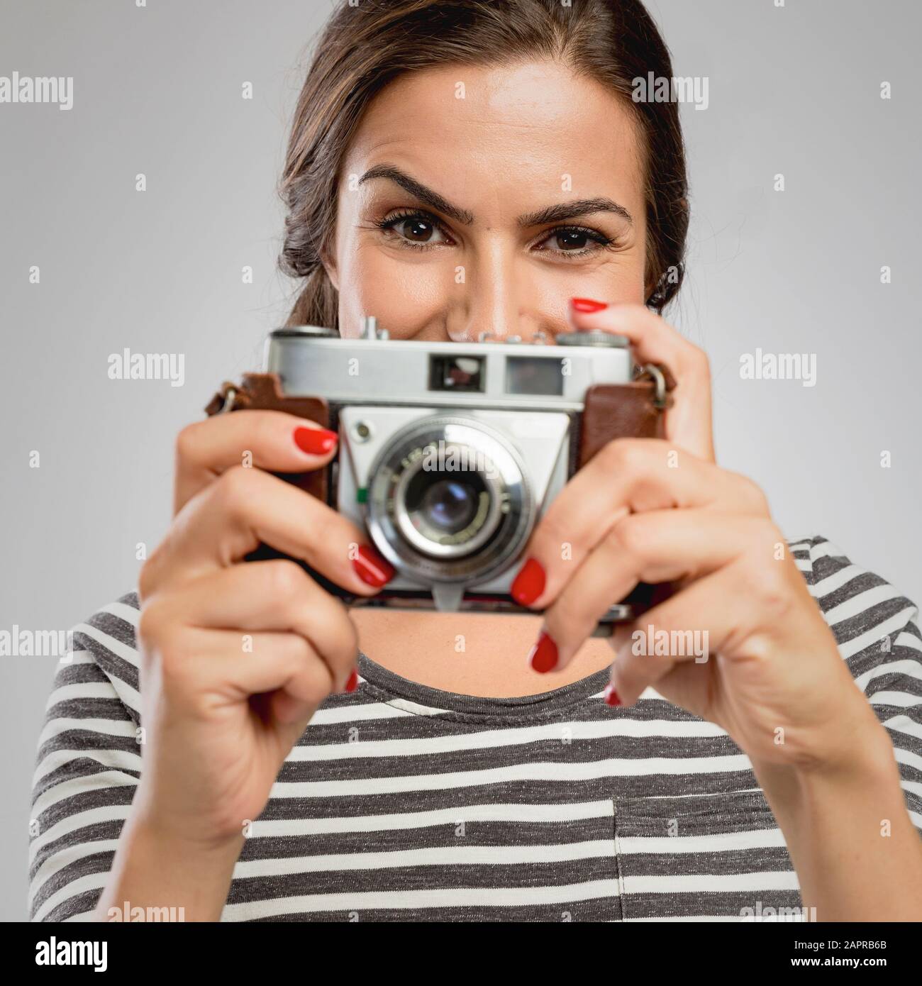 Beautiful woman holding her vintage camera over the face Stock Photo ...